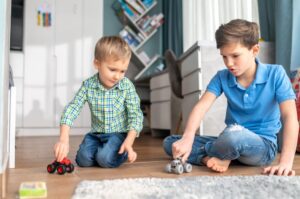 Two siblings playing with model cars
